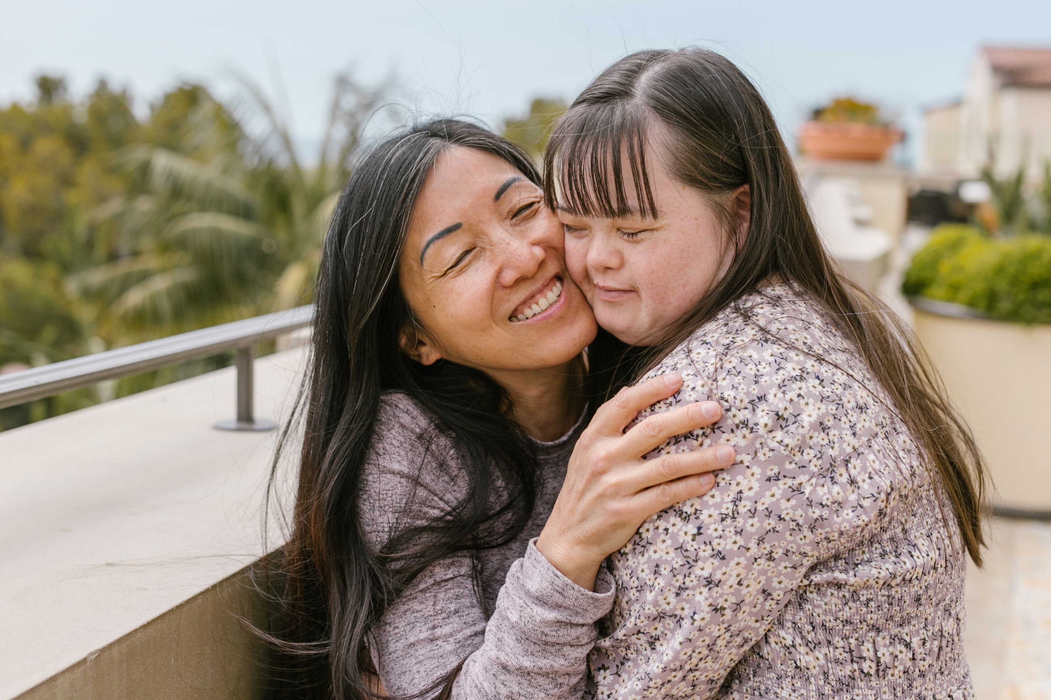 A mother and adult daughter sharing a warm moment at home